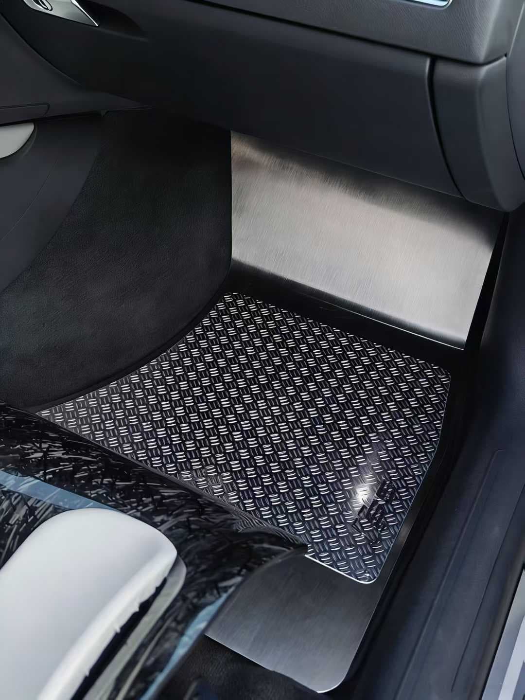 Actual ribbed metal floor mat installed in a black daily-driver interior